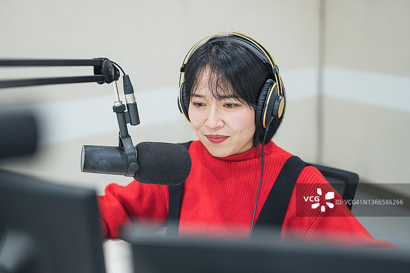 年轻漂亮的亚洲女主播在直播间直播图片素材