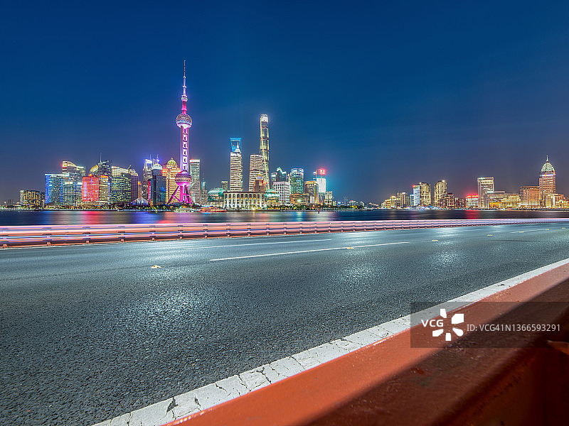 汽车广告背板，夜晚上海城市天际线前的空旷道路图片素材