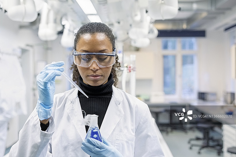 女科学家在医学研究实验室研究化学品图片素材
