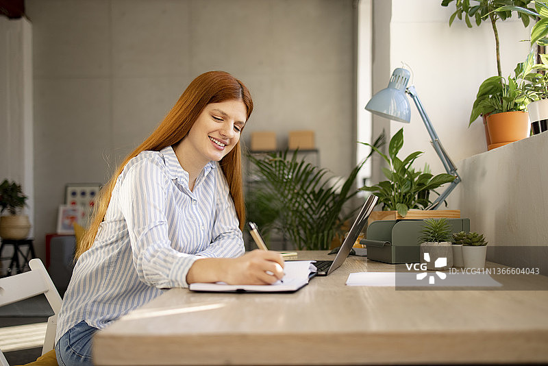 成功的白人女性在家用笔记本电脑工作图片素材