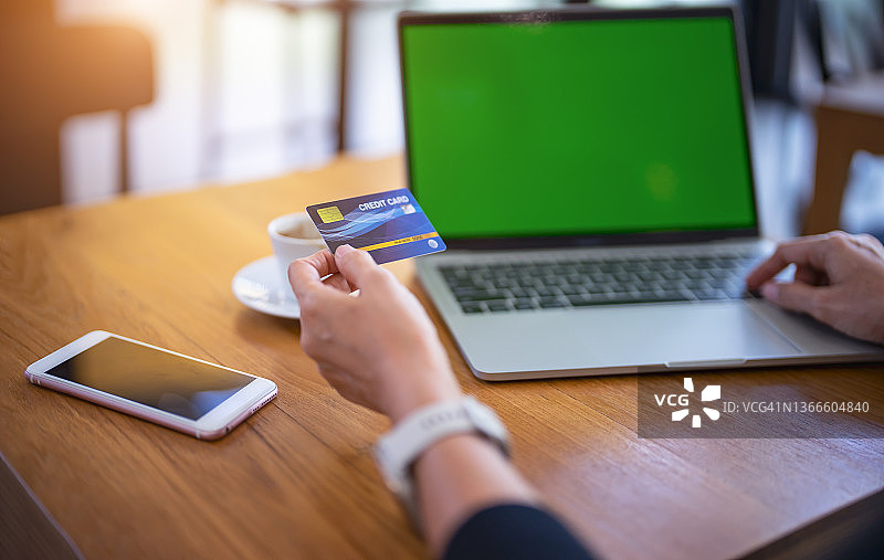 手持信用卡使用笔记本电脑，居家办公的女商人或企业家图片素材