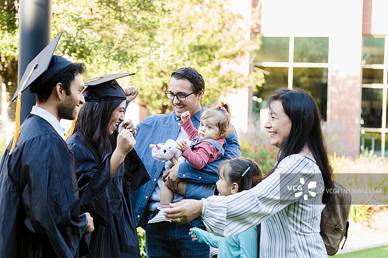 多代同堂家庭毕业后微笑拥抱图片素材