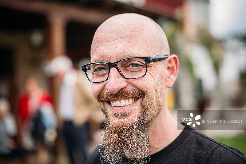 戴着眼镜的留着胡须的男人对着镜头微笑的画像图片素材