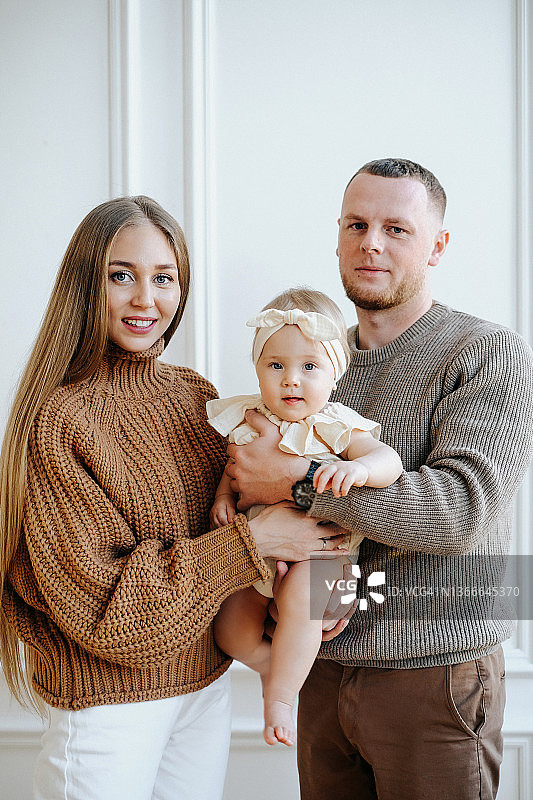 全家福：妈妈、爸爸和一岁的宝宝看着镜头图片素材