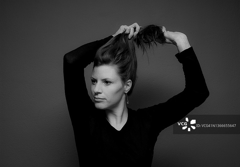 一位年轻女子将头发扎成马尾辫的照片图片素材