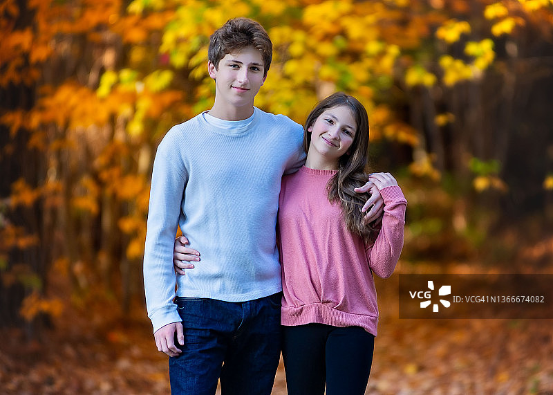 站在树林边缘的年轻兄妹图片素材