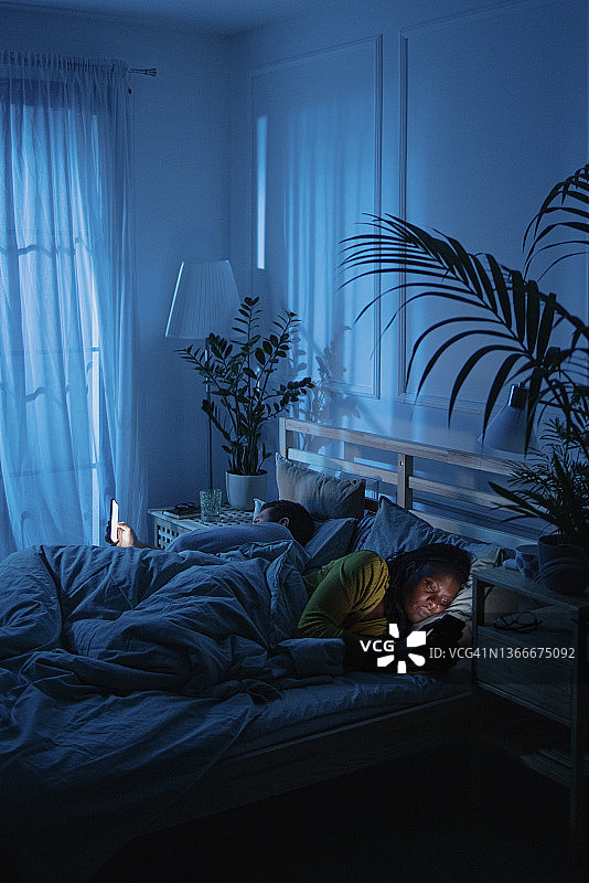 情侣各自使用智能手机，互不理睬图片素材