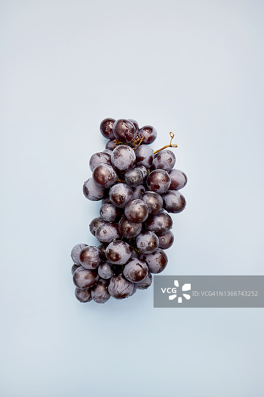 蓝色背景下的一串葡萄高角度视图图片素材