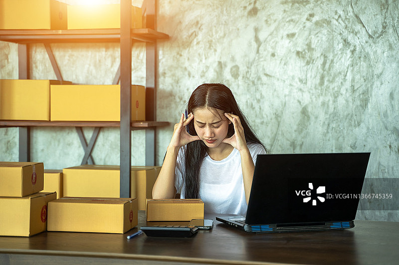 亚洲女店主被顾客惹恼，情绪烦闷地工作，在线销售图片素材