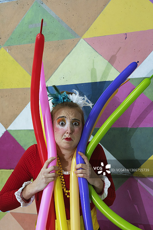 小丑女孩和马戏团表演者在演出前进行热身运动，喜剧演员玩气球图片素材