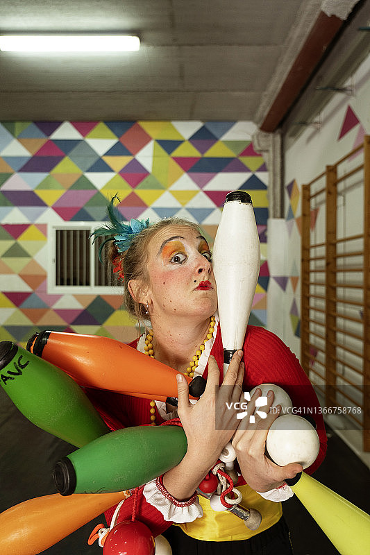 小丑和马戏团演员在演出前进行热身运动的场景图片素材