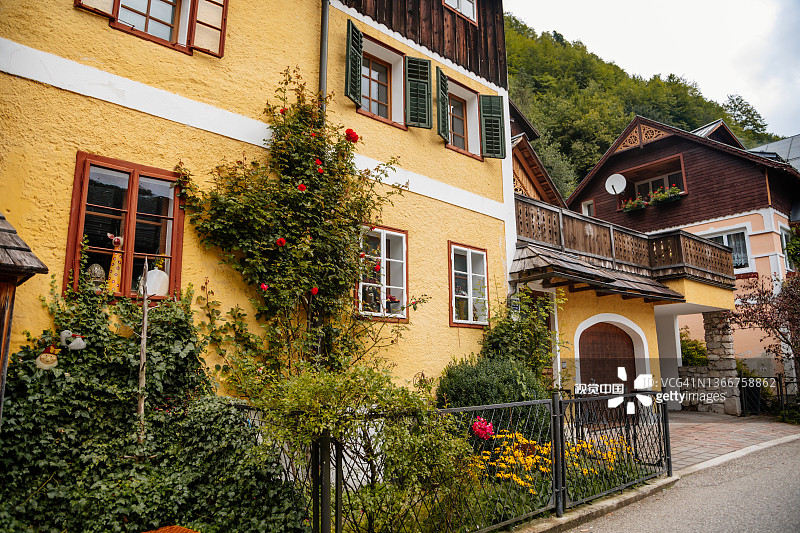 夏季风景如画的城镇街道，靠近湖泊和阿尔卑斯山的山村，联合国教科文组织遗产，传统房屋，木制阳台，盆栽鲜花图片素材