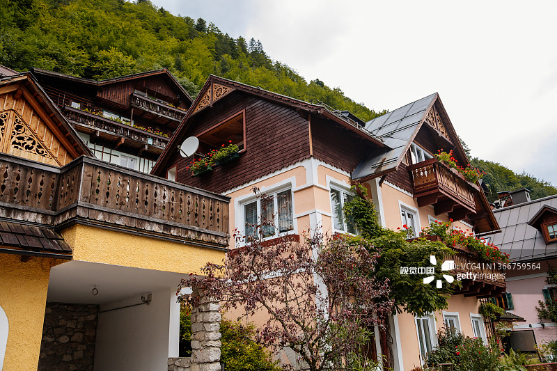 夏季风景如画的城镇街道，靠近湖泊和阿尔卑斯山的山村，联合国教科文组织遗产，传统房屋，木制阳台，盆栽鲜花图片素材