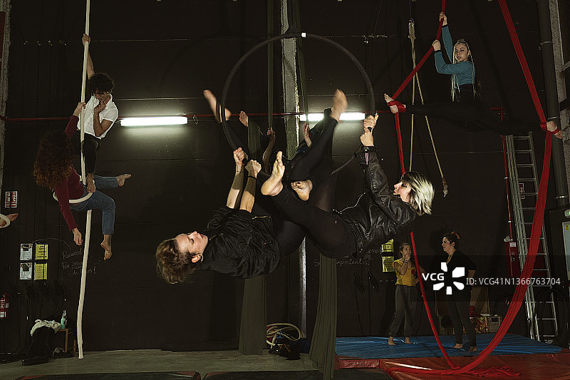 接受训练的马戏团杂技演员悬挂在绳索上表演图片素材