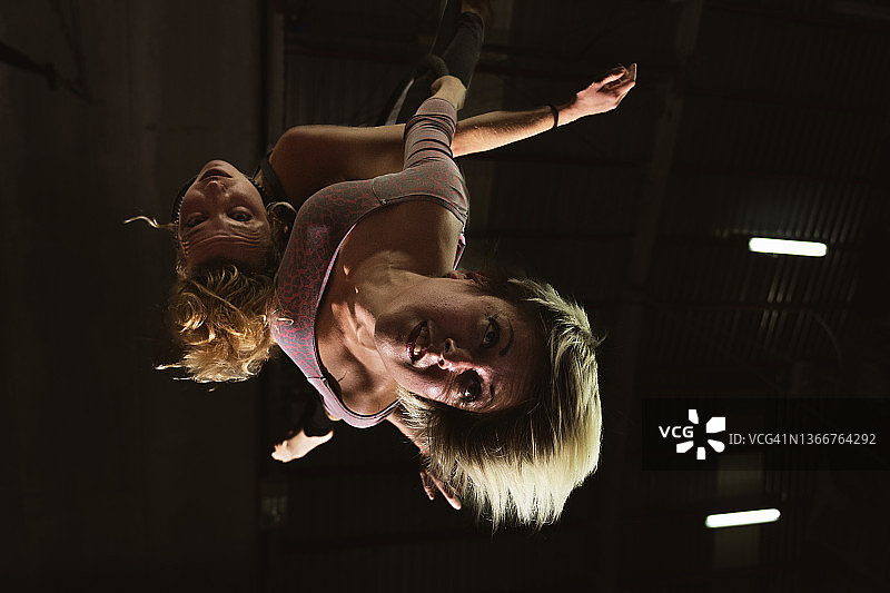 一对训练有素的女性马戏团杂技演员悬挂在绳索、杂技织物和空中舞蹈上，喜剧马戏团表演者图片素材