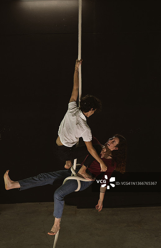 接受过训练的马戏团杂技演员悬挂在绳索上图片素材