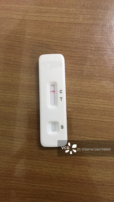 棕色木质背景上的ATK抗原测试套件新冠病毒测试图片素材