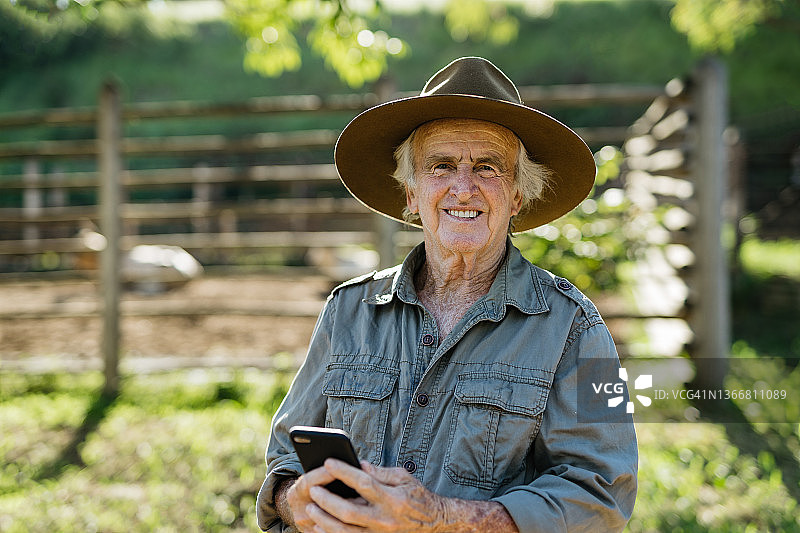 农民拿着智能手机的肖像图片素材