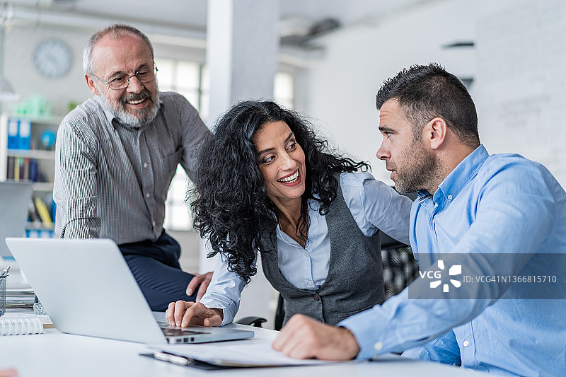 在现代办公室中使用笔记本电脑进行团队合作图片素材