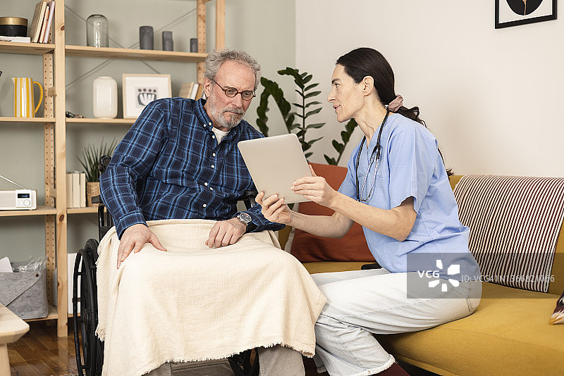 护士向坐在轮椅上的病人展示医疗结果图片素材