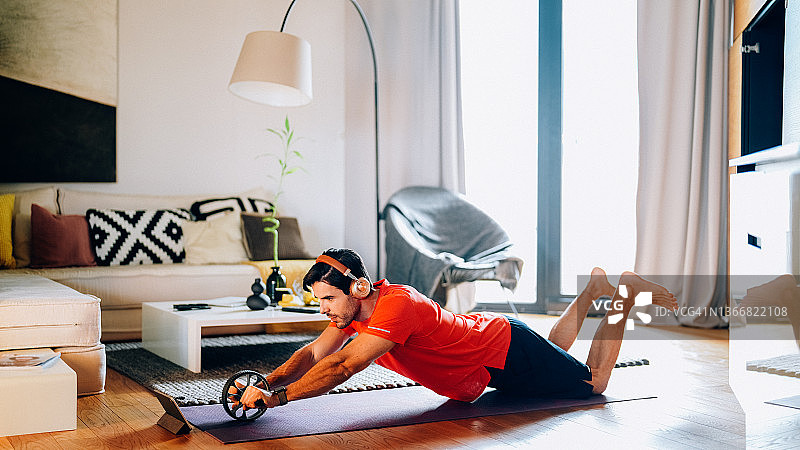 在家使用健腹轮锻炼的男人图片素材