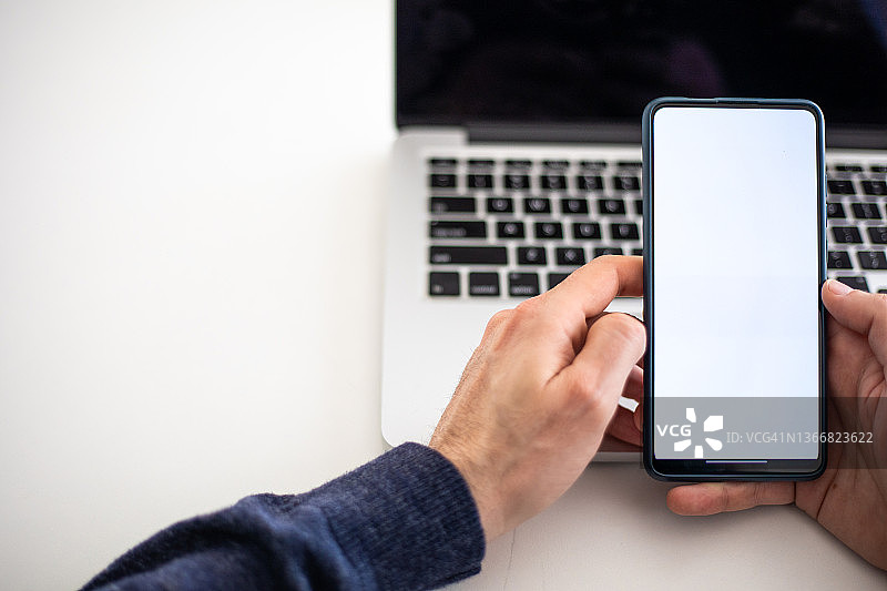 年轻男人拿着带白色屏幕的手机-广告模型图片素材