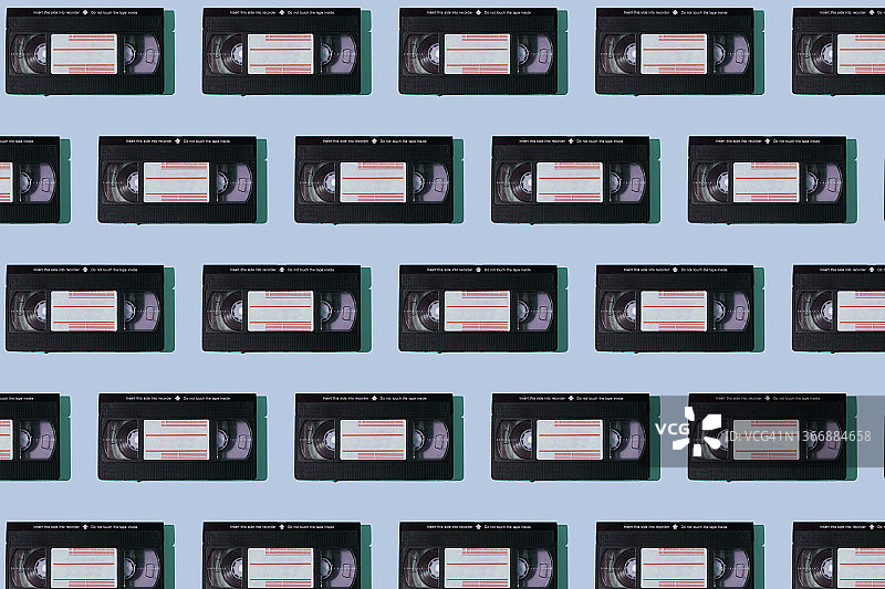 蓝色背景上的黑色VHS录像带图案：录像、电影、复古磁带图片素材