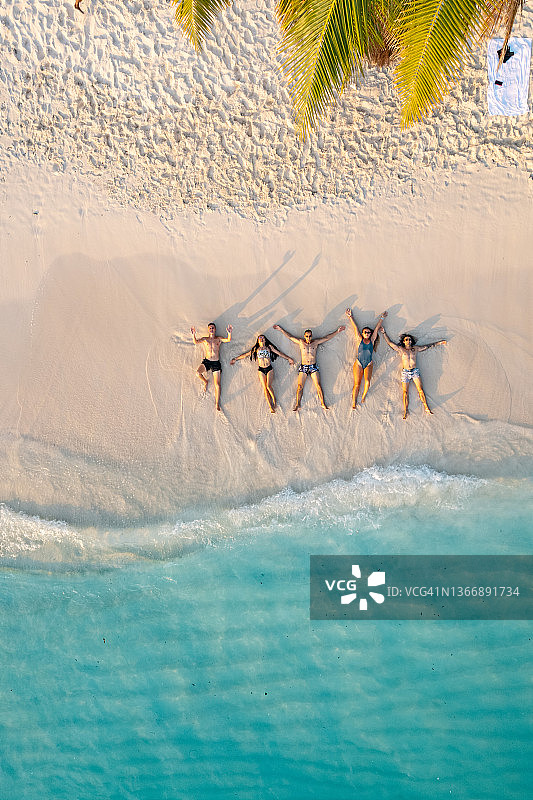 朋友们躺在沙滩上的航拍图片素材