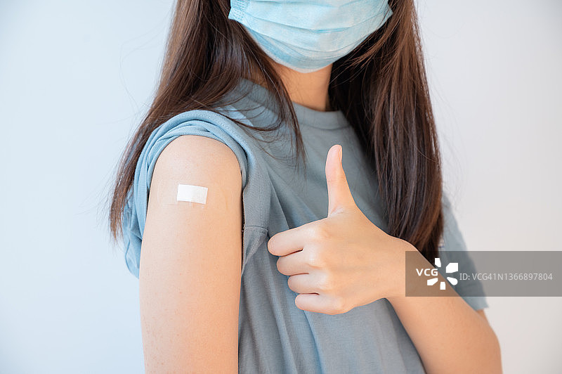 亚洲女人接种疫苗后露出肩膀。接种新冠疫苗可以降低感染和传播新冠病毒的风险。图片素材