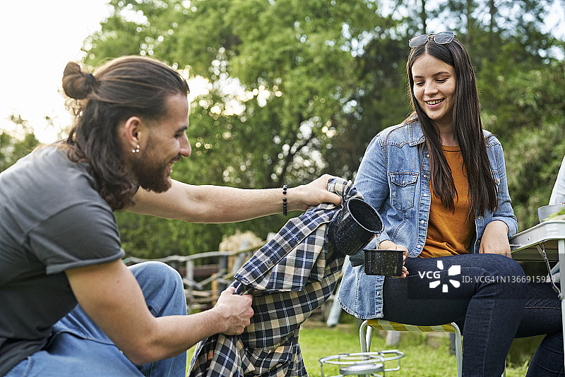 20多岁的情侣露营喝热饮图片素材
