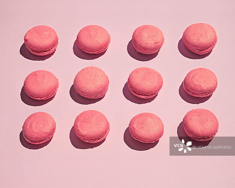 粉色背景上的十二个粉色马卡龙图片素材