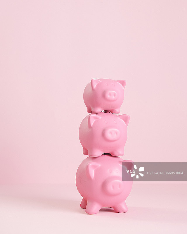 三个粉色存钱罐堆叠在一起，最小的在顶部，最大的在底部图片素材