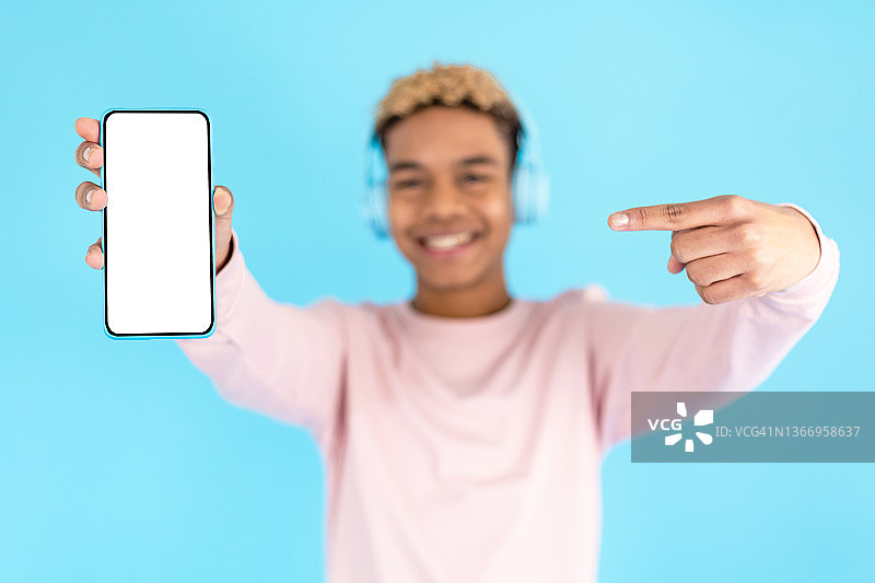 快乐的年轻人展示带空白屏幕的智能手机图片素材