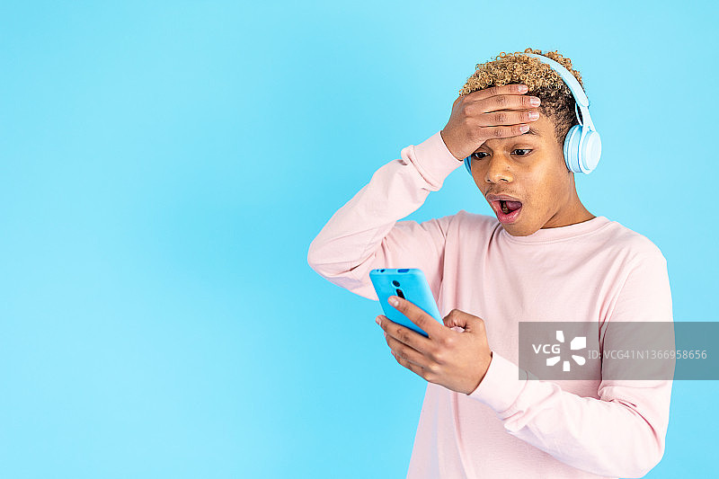 年轻人震惊地看着手机图片素材