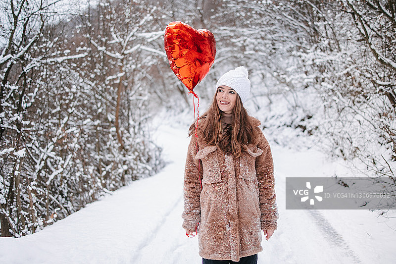 年轻女人手持心形热气球图片素材
