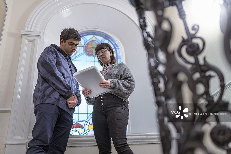 低角度拍摄的社工与男子在走廊交谈图片素材