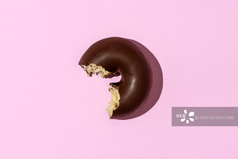 粉色背景上的巧克力甜甜圈图片素材
