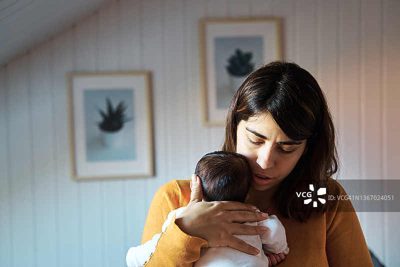 母亲为新生婴儿唱摇篮曲哄睡的正面照图片素材