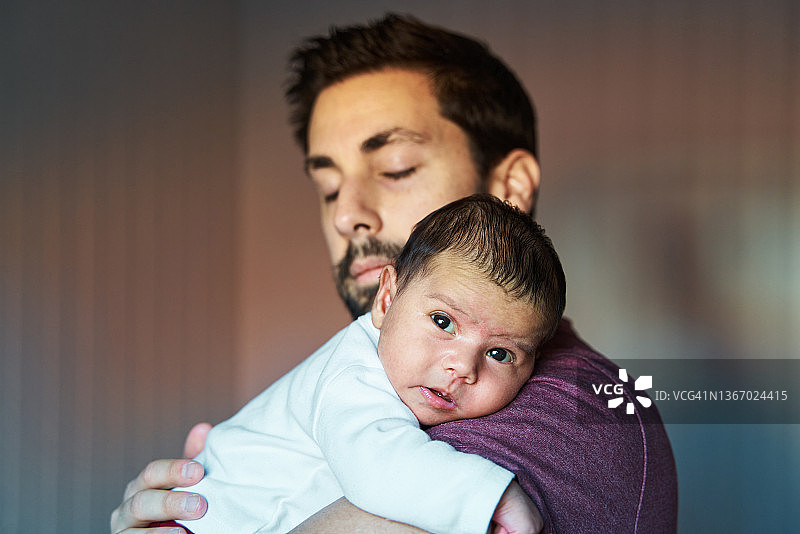 父亲闭着眼睛抱着宝宝走路的侧视图图片素材