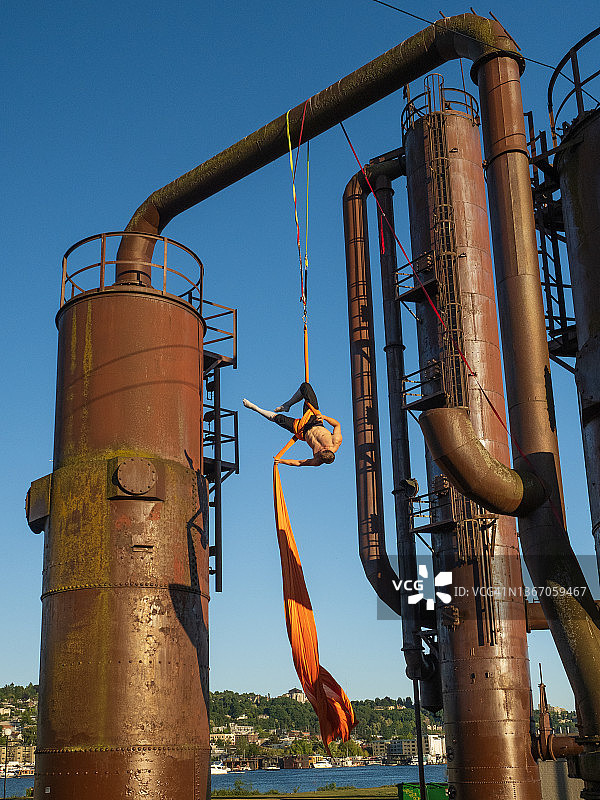男空中飞人在工业场所表演绸吊图片素材