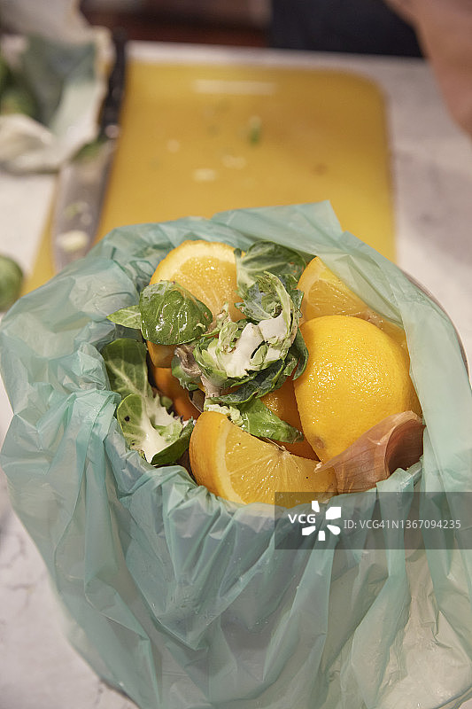 装有橙子和球芽甘蓝的厨房堆肥桶图片素材