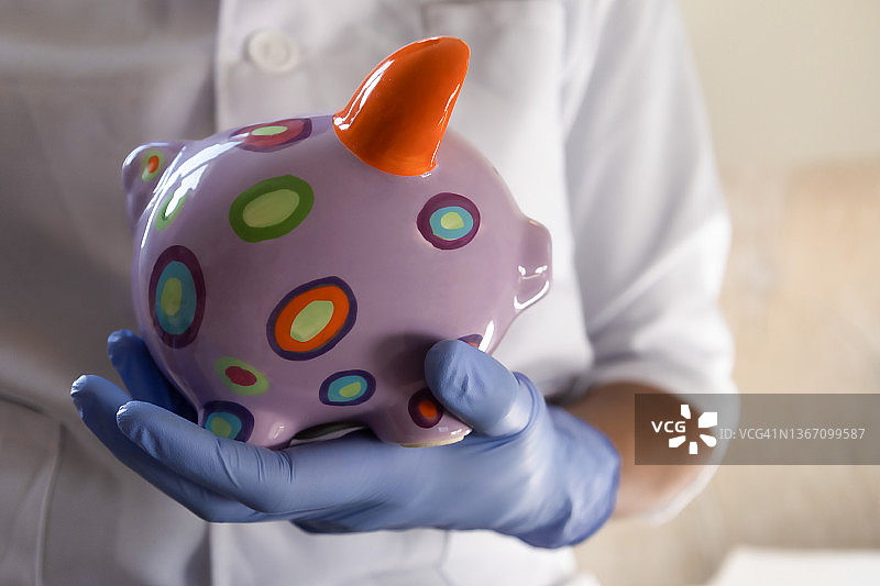 医护人员拿着色彩鲜艳的储蓄罐图片素材