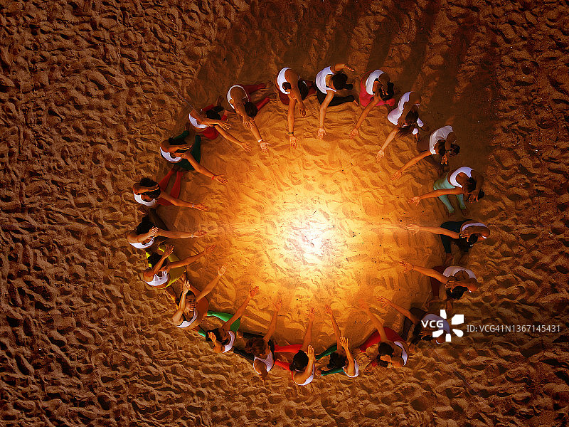 健康的女性在海滩户外一起做瑜伽，团队合作概念图片素材