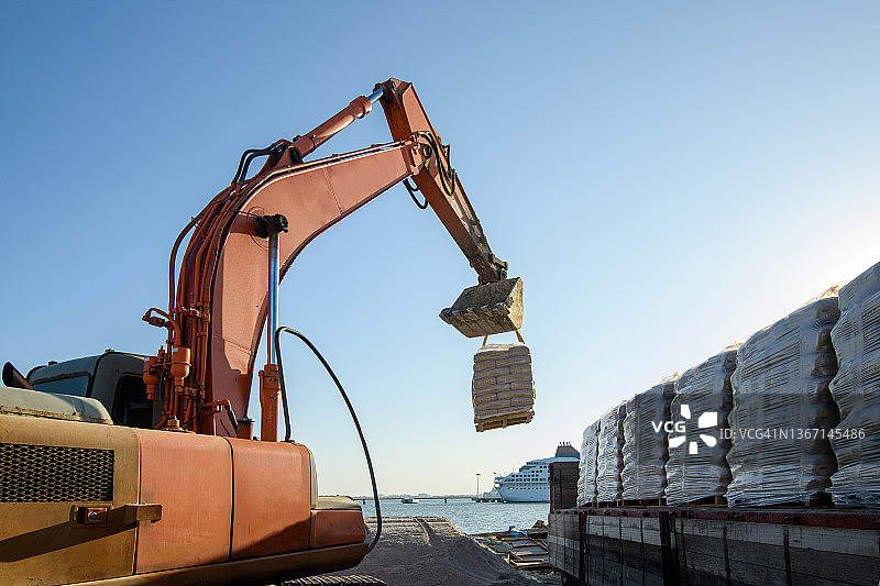 挖掘机从卡车上卸水泥图片素材