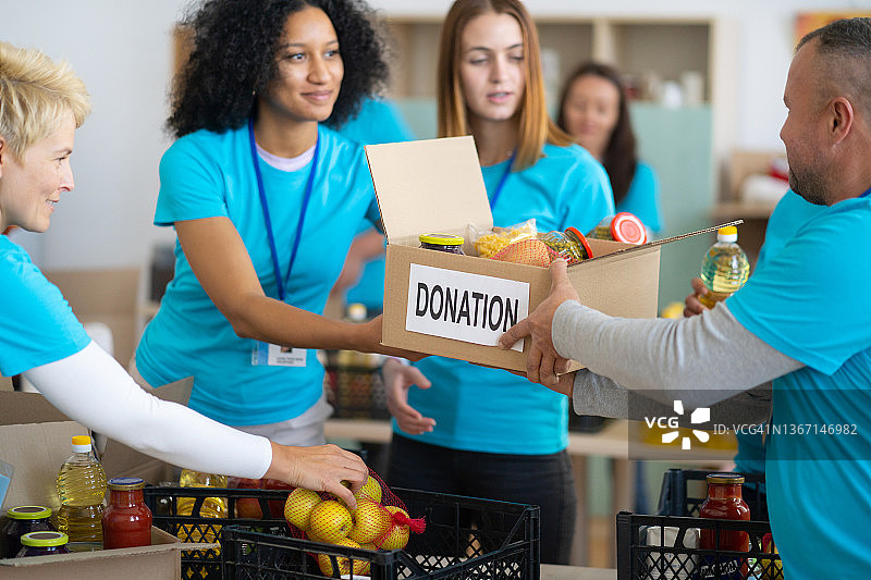 青年志愿者整理捐赠物品，参与慈善食品募集活动图片素材