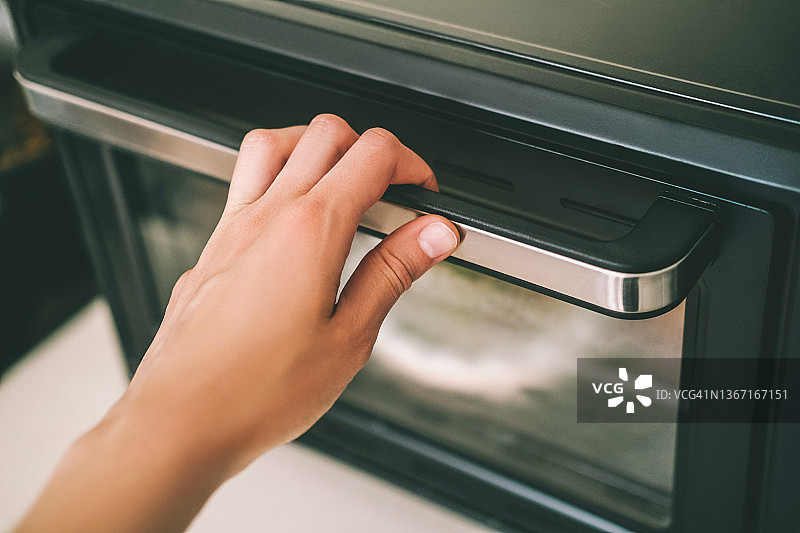 手握烤箱门把手图片素材