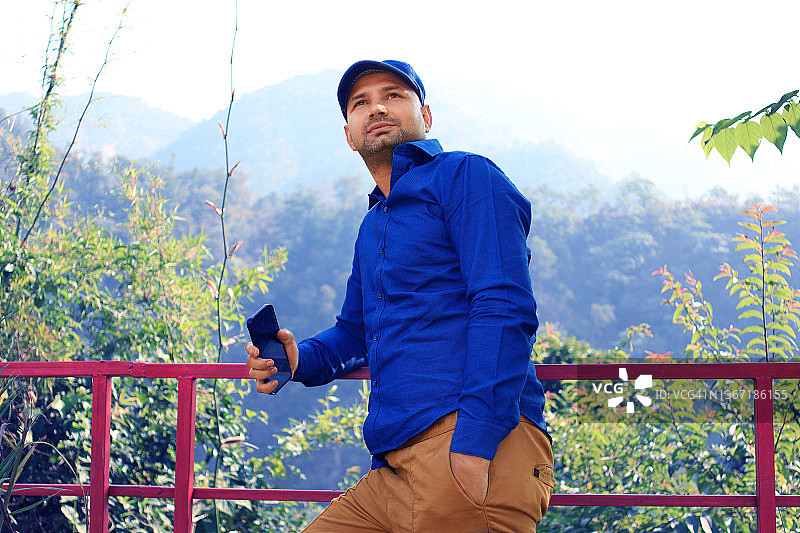 站在印度北阿坎德邦瑞诗凯诗山中栏杆附近的年轻男人图片素材