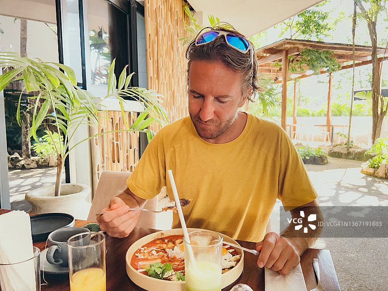 在咖啡馆享用美味早餐的年轻男人图片素材