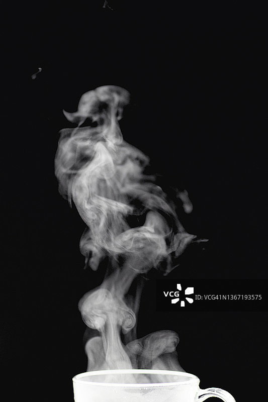黑色背景上茶或咖啡的白色抽象蒸汽图片素材
