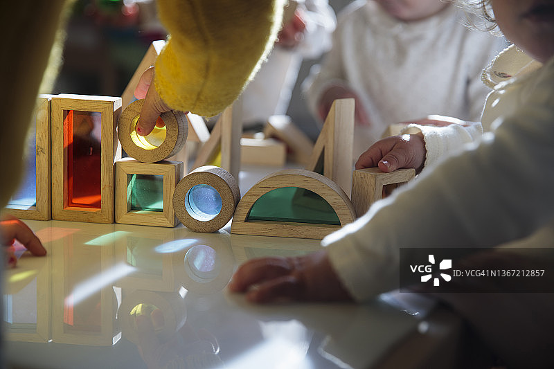 小朋友在桌子上玩彩色积木图片素材